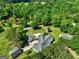Stunning aerial view of the home with an expansive roof, multiple garages and outbuildings surrounded by green space at 228 Indian Creek Rd, Locust Grove, GA 30248