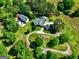 Stunning aerial view of a beautiful estate with sprawling green lawns, circular driveway, and lush trees surrounding the property at 228 Indian Creek Rd, Locust Grove, GA 30248