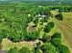 Expansive property featuring a lush landscape, tranquil pond, and well-maintained home nestled among mature trees at 228 Indian Creek Rd, Locust Grove, GA 30248