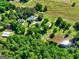 Gorgeous aerial shot featuring a sprawling estate with a barn, pond, lush landscaping and a long driveway amid mature trees at 228 Indian Creek Rd, Locust Grove, GA 30248