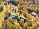 Sprawling estate with multiple buildings, a pond, and a barn, all surrounded by lush trees and greenery at 228 Indian Creek Rd, Locust Grove, GA 30248