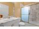 Bathroom featuring marble walls and countertop, white cabinets, gold trim and a glass sliding door at 228 Indian Creek Rd, Locust Grove, GA 30248