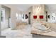 Spacious bathroom boasts marble floors and walls, a soaking tub, separate shower, and double vanity at 228 Indian Creek Rd, Locust Grove, GA 30248