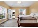 Bedroom features wood floors, light yellow walls, ceiling fan, lots of windows, and a door to the outside at 228 Indian Creek Rd, Locust Grove, GA 30248
