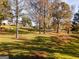 Expansive yard with mature trees, a wooden fence, and a glimpse of a charming home in the background at 228 Indian Creek Rd, Locust Grove, GA 30248