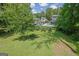 A well-maintained backyard with an in-ground swimming pool and mature trees on a sunny day at 2673 Deerfield Sw Cir, Marietta, GA 30064