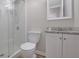Bathroom featuring a stand-up shower with glass doors, a white toilet, and a granite countertop at 2673 Deerfield Sw Cir, Marietta, GA 30064