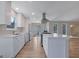 Modern kitchen with white cabinets, stainless steel appliances, island, and open layout with wood-look flooring at 2673 Deerfield Sw Cir, Marietta, GA 30064
