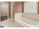 Bright bathroom with soaking tub, glass block window, and separate shower stall at 1118 Sequoia Trl, Mcdonough, GA 30252