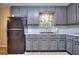 This kitchen features gray cabinets, subway tile backsplash, and a black refrigerator at 2066 Tidwell Trl, Stone Mountain, GA 30088