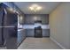 Modern kitchen with gray cabinets, subway tile backsplash, and sleek black appliances with vinyl flooring at 2066 Tidwell Trl, Stone Mountain, GA 30088