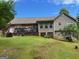 Expansive backyard features a large deck, lush lawn, mature trees, and exterior of the home at 1137 Eagles Nest Cir, Carrollton, GA 30116