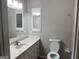 Bathroom with a white vanity, sink, toilet, and large mirror at 1170 5Th Ave, Jonesboro, GA 30236