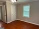 Cozy bedroom featuring wood floors, a ceiling fan, and a bright window at 1170 5Th Ave, Jonesboro, GA 30236