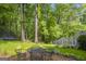 Backyard patio with metal table and chairs surrounded by green grass and trees at 770 River Cove Dr, Dacula, GA 30019