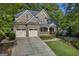 Inviting brick home showcasing a manicured lawn, two-car garage, and covered front porch at 770 River Cove Dr, Dacula, GA 30019