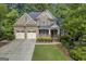 Charming brick home featuring a two-car garage, front porch, and lush landscaping at 770 River Cove Dr, Dacula, GA 30019