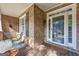Enclosed front porch with brick columns, a seating area, and a glass front door at 770 River Cove Dr, Dacula, GA 30019