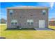 Exterior view of the brick home showing backyard with ample lawn and access via glass paneled doors at 600 Dairy Dr, Stockbridge, GA 30281