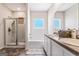 Well-lit bathroom featuring double sinks, bathtub, and glass door shower at 600 Dairy Dr, Stockbridge, GA 30281