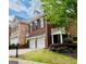 Red brick townhome with white columns, manicured lawn, and a two-car garage at 11945 Dancliff Trce, Alpharetta, GA 30009