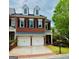Charming red brick townhome featuring a two-car garage and dormer windows at 11945 Dancliff Trce, Alpharetta, GA 30009