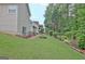 A spacious backyard with a lawn, manicured landscaping, mulch beds, and mature trees at 323 Newfield Way, Peachtree City, GA 30269
