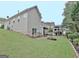 An angled exterior shot of a house and spacious backyard with a lawn and mature trees at 323 Newfield Way, Peachtree City, GA 30269