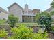 Home's backyard boasts a lush lawn, mature landscaping, and a charming two-story deck at 323 Newfield Way, Peachtree City, GA 30269