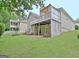 Exterior view of the home with a well-maintained lawn, deck and a covered patio below at 323 Newfield Way, Peachtree City, GA 30269
