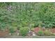 An elevated view of a backyard with manicured landscaping, mulch beds, and lush trees at 323 Newfield Way, Peachtree City, GA 30269