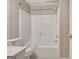 Bathroom featuring a shower-tub combo with patterned wallpaper at 323 Newfield Way, Peachtree City, GA 30269