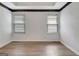Empty bedroom showcasing wood floors, a tray ceiling, and natural light from the windows at 323 Newfield Way, Peachtree City, GA 30269