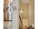 Hallway near the kitchen with access to the basement stairs and stainless steel refrigerator at 323 Newfield Way, Peachtree City, GA 30269