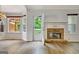 Bright living room featuring a stone fireplace, wood floors, bay window, and access to an outdoor deck at 323 Newfield Way, Peachtree City, GA 30269