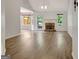 Open living room with fireplace, wood floors, and an adjoining sunroom at 323 Newfield Way, Peachtree City, GA 30269