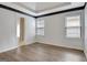 Bright main bedroom featuring wood floors, a tray ceiling, and two windows bringing in natural light at 323 Newfield Way, Peachtree City, GA 30269