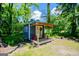 Charming cottage-style shed with a covered porch and red chairs at 527 W Church St, Villa Rica, GA 30180