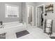 Bright bathroom features a soaking tub, tiled floors, and a glass block window for privacy at 119 Crown Springs Dr, Mcdonough, GA 30252
