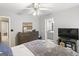 Bedroom features neutral walls and carpet, a ceiling fan, and a bathroom with gray cabinets at 119 Crown Springs Dr, Mcdonough, GA 30252