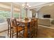 Spacious eat-in kitchen with wood floors, large table, modern lighting, and access to the living room at 119 Crown Springs Dr, Mcdonough, GA 30252