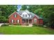 Charming two-story red brick home with lush green lawn, mature trees, and manicured landscaping at 119 Crown Springs Dr, Mcdonough, GA 30252