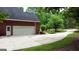 Attached garage and driveway surrounded by mature trees and landscaping at 119 Crown Springs Dr, Mcdonough, GA 30252