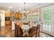 Sunlit kitchen features a breakfast area with a wood table, hardwood floors and view of the backyard at 119 Crown Springs Dr, Mcdonough, GA 30252
