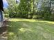 The large, flat backyard features green grass and mature trees with an AC unit at 105 Harris Ct, Stockbridge, GA 30281