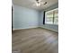 Bedroom with light blue walls, wood-look flooring, a ceiling fan, and a window at 105 Harris Ct, Stockbridge, GA 30281