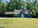 Charming blue home with a well-manicured lawn and a convenient covered carport at 105 Harris Ct, Stockbridge, GA 30281