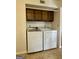 This laundry room features a modern washer and dryer set and convenient overhead cabinetry for storage at 105 Harris Ct, Stockbridge, GA 30281