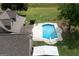 Aerial view of a backyard with an in-ground pool, lush lawn, and a charming brown house, blending comfort with outdoor splendor at 411 Hampton Rd, Fayetteville, GA 30215