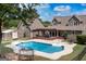 Aerial view of backyard with in-ground pool, shed, deck, fenced yard, and mature trees at 411 Hampton Rd, Fayetteville, GA 30215
